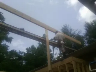 Carpenter setting a ridge beam over a new addition frame — Ice Dam Removal by Roofing Brothers in Dutch Flat