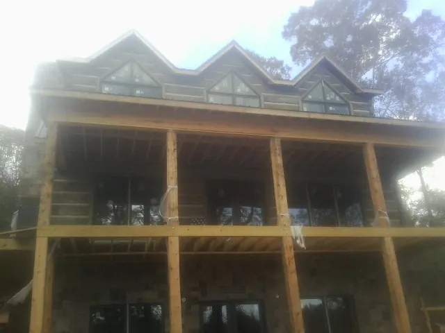 Dormers and porch framing on a large log home under construction — Roof Coating work by our crew in Dutch Flat