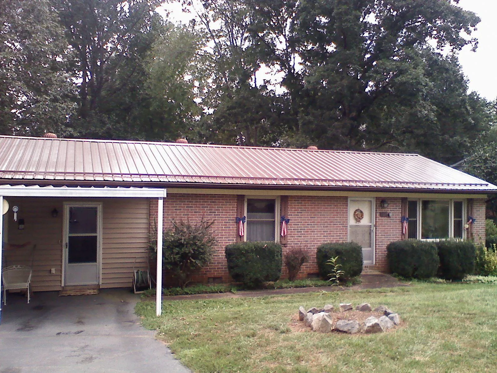 Bronze metal roof and carport on a brick ranch home — Roof Repair work by our crew in Dutch Flat